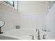 A luxurious bathtub is tiled with a stained glass window above for natural light at 5058 Antebellum Dr, Iron Station, NC 28080