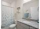 Well-lit bathroom with granite countertop, white cabinetry, and a shower with a floral curtain at 5058 Antebellum Dr, Iron Station, NC 28080