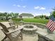 Stone fire pit area with patio and Adirondack chairs in a landscaped backyard at 5058 Antebellum Dr, Iron Station, NC 28080