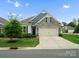 Charming single-story home with stone accents, a two-car garage, and a well-manicured front lawn at 5058 Antebellum Dr, Iron Station, NC 28080