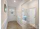 Bright hallway with paneled wainscotting, hardwood floors, leading to a bedroom with a blue bedspread at 5058 Antebellum Dr, Iron Station, NC 28080