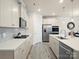 Bright kitchen features stainless appliances, gas cooktop, tile backsplash, and large island with sink and dishwasher at 5058 Antebellum Dr, Iron Station, NC 28080