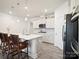 Bright kitchen features stainless appliances, tile backsplash, and island with bar top and seating at 5058 Antebellum Dr, Iron Station, NC 28080