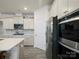 Bright kitchen features stainless appliances, tile backsplash, and island with bar top and seating at 5058 Antebellum Dr, Iron Station, NC 28080