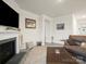 Comfortable living room with a fireplace, plush carpeting, and a large leather sofa and various accent pieces at 5058 Antebellum Dr, Iron Station, NC 28080