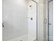 White tiled standing shower with glass door and brushed metal shower head at 5058 Antebellum Dr, Iron Station, NC 28080