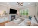 Comfortable living room with a fireplace, large windows, and a plush sectional sofa at 5210 Valley Stream Rd, Charlotte, NC 28209
