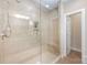 Walk-in shower with beige tile and glass door showcasing built-in shelving at 5210 Valley Stream Rd, Charlotte, NC 28209