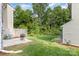 Backyard featuring lush greenery and a patio area with a grill, perfect for outdoor relaxation and entertaining at 5257 Glenlea Walk Ln, Charlotte, NC 28216
