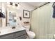 Well-lit bathroom featuring a gray vanity, framed art, and a neutral shower curtain, seamlessly blending style and functionality at 5257 Glenlea Walk Ln, Charlotte, NC 28216