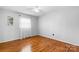 Minimalist bedroom with hardwood flooring, a window with sheer curtains, and light gray walls at 5486 Suttlemyre Ln, Hickory, NC 28601