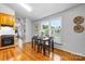 Bright dining area features wood floors, a dark wood table with seating, and sunny windows with white shutters at 5486 Suttlemyre Ln, Hickory, NC 28601