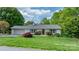 Charming single-story home with a well-maintained lawn, mature trees, and a classic brick exterior creating a serene setting at 5486 Suttlemyre Ln, Hickory, NC 28601
