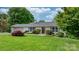 Front exterior of charming home with lush green yard and manicured landscaping at 5486 Suttlemyre Ln, Hickory, NC 28601