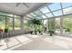 Bright sunroom featuring a glass ceiling, neutral carpeting, and an array of potted plants offering views of the outdoors at 5486 Suttlemyre Ln, Hickory, NC 28601