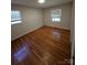 Inviting bedroom with gleaming wood floors, natural lighting, and two windows offering neighborhood views at 6212 Snowcrest Ct, Charlotte, NC 28212