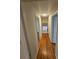 Hallway with hardwood floors and neutral paint, leading to various rooms and offering a cohesive design at 6212 Snowcrest Ct, Charlotte, NC 28212
