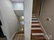 A staircase connecting two levels of the home, featuring wooden steps and a neutral color scheme at 6212 Snowcrest Ct, Charlotte, NC 28212