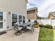 A patio area features a modern outdoor dining set, lush grass, and an outdoor kitchen area at 6312 Kennard Dr, Charlotte, NC 28216