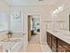 Bright bathroom with double vanity, soaking tub, and doorway leading into bedroom at 6312 Kennard Dr, Charlotte, NC 28216