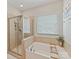 Clean, bright bathroom with a glass-enclosed shower and a soaking tub next to a window at 6312 Kennard Dr, Charlotte, NC 28216