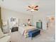 Spacious bedroom featuring a tufted headboard, colorful blue chest, and sun-filled windows with a neighborhood view at 6312 Kennard Dr, Charlotte, NC 28216