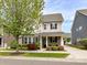 Charming two-story home with gray siding, black shutters and a beautifully landscaped front yard at 6312 Kennard Dr, Charlotte, NC 28216