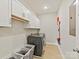 Laundry room features a side-by-side washer and dryer, tile floors, and white cabinets at 6312 Kennard Dr, Charlotte, NC 28216