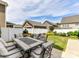 Back patio area features a modern outdoor dining set, lush grass, and an outdoor kitchen area at 6312 Kennard Dr, Charlotte, NC 28216