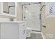 Modern bathroom with white vanity, quartz countertop, and glass shower with marble tile surround at 6600 Knightswood Dr, Charlotte, NC 28226