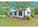 Side view of a well-maintained home featuring classic shutters and lush landscaping at 6600 Knightswood Dr, Charlotte, NC 28226