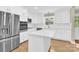 This is a bright kitchen with an island, all white cabinetry, stainless appliances, and hardwood flooring at 6600 Knightswood Dr, Charlotte, NC 28226