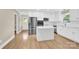 Bright kitchen features white cabinetry, stainless steel appliances, an island, and hardwood flooring at 6600 Knightswood Dr, Charlotte, NC 28226
