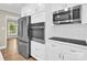 Well-lit kitchen boasts stainless steel appliances, white cabinetry, subway tile backsplash, and hardwood floors at 6600 Knightswood Dr, Charlotte, NC 28226