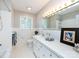 Well-lit bathroom with a tiled tub/shower, white vanity, and ample counter space at 6616 Williams Rd, Charlotte, NC 28215