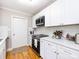 Bright kitchen features white cabinets, subway tile backsplash, hardwood floors and stainless appliances at 6616 Williams Rd, Charlotte, NC 28215