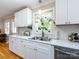 Bright kitchen features white cabinets, stainless steel sink and appliances, plus backyard view at 6616 Williams Rd, Charlotte, NC 28215