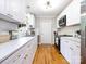 Bright kitchen features white cabinets, subway tile backsplash, hardwood floors and stainless appliances at 6616 Williams Rd, Charlotte, NC 28215