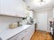 Bright kitchen features white cabinets, hardwood floors, stainless steel appliances and backyard views at 6616 Williams Rd, Charlotte, NC 28215