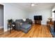 Bright living room features hardwood floors, comfortable gray sofa and a television at 6616 Williams Rd, Charlotte, NC 28215