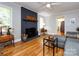 Spacious living room featuring a painted brick fireplace with hardwood floors at 6616 Williams Rd, Charlotte, NC 28215
