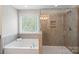 Bathroom with a soaking tub and glass shower enclosure, offering a clean and relaxing space at 7039 Chrysanthemum Rd, Lancaster, SC 29720