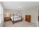Bright bedroom featuring neutral-colored walls, a four-poster bed, carpeted floors, and natural lighting at 7039 Chrysanthemum Rd, Lancaster, SC 29720