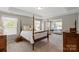 Spacious main bedroom with a four-poster bed, sitting area, and windows providing lots of natural light at 7039 Chrysanthemum Rd, Lancaster, SC 29720
