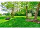 Lush backyard with a fire pit and storage shed surrounded by mature trees at 704 E Catawba St, Belmont, NC 28012