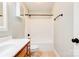 Bright bathroom featuring a white shower-tub combination, white cabinets, and neutral walls at 704 E Catawba St, Belmont, NC 28012