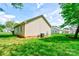Exterior side view showcasing the home's siding, lush lawn, and mature trees at 704 E Catawba St, Belmont, NC 28012