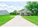 View of the property, with a long driveway and manicured lawn leading to the cozy home at 704 E Catawba St, Belmont, NC 28012
