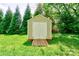 Backyard storage shed with double doors, nestled among mature trees, offering ample storage at 704 E Catawba St, Belmont, NC 28012
