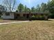 Ranch home showcasing a brick facade, front porch, and mature landscaping at 785 Nc Highway 109 N Hwy, Troy, NC 27371